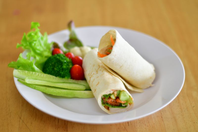 Vegan roasted veggie wrap with pesto and sun-dried tomatoes